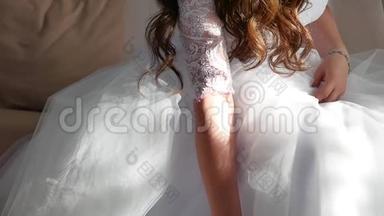 新娘`早上。 好艺术婚礼。 新娘的双手特写躺在室内的白色礼服上